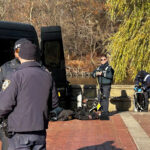 NYPD officers search a pond in Central Park for evidence related to the Brian Thompson shooting.