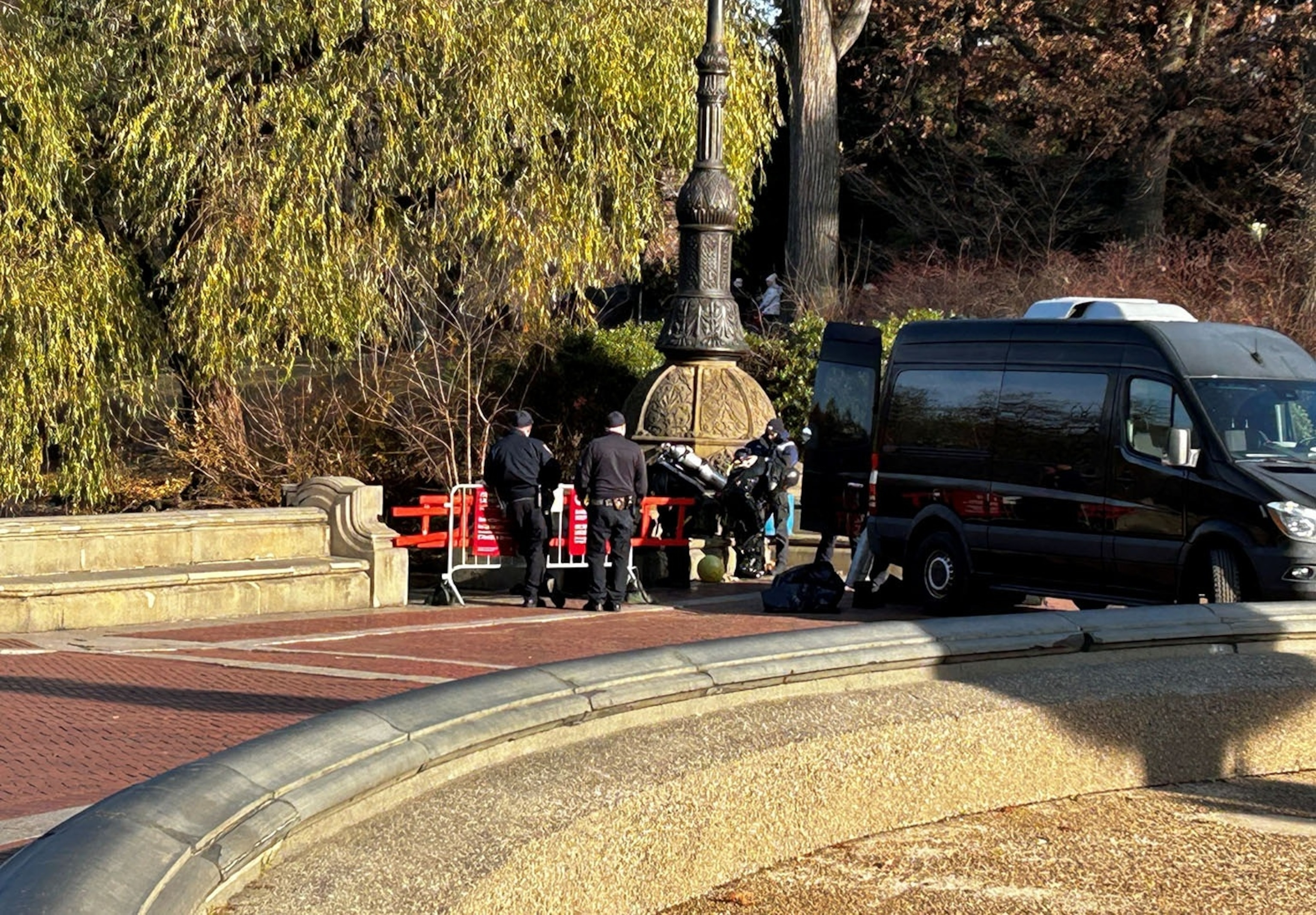 NYPD officers searching the pond in Central Park as part of the investigation into the CEO shooting, focusing on recovering potential evidence like the murder weapon.