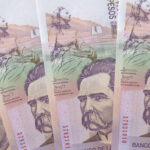 Stacks of Colombian Peso banknotes illustrating Colombian money vs US dollar exchange rate.
