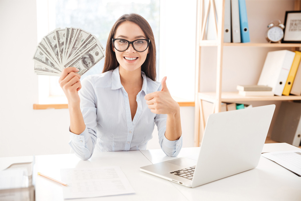 Girl with money giving thumbs up