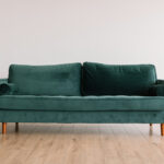 Green velvet sofa in an empty room