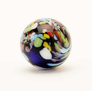 Close-up of Christensen Agate Co. Guinea marbles with transparent base and colored flecks