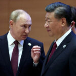 Russian President Vladimir Putin speaks with Chinese President Xi Jinping before an extended-format meeting of heads of the Shanghai Cooperation Organization summit (SCO) member states in Samarkand, Uzbekistan September 16, 2022, illustrating the financial partnership between Russia and China.