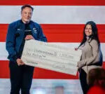 Elon Musk presents a one million dollar check during a town hall