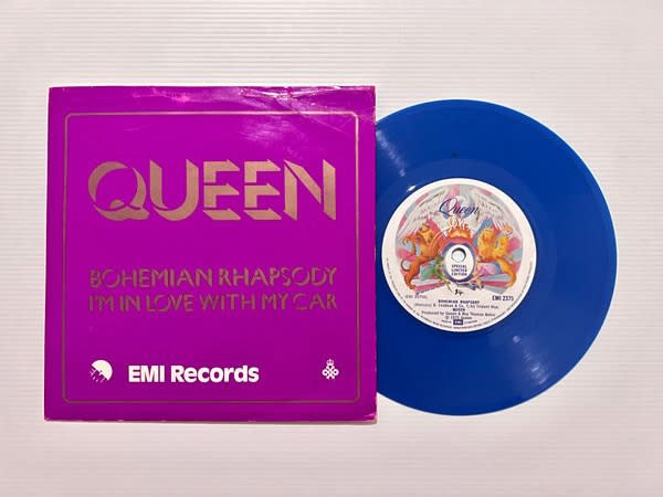 A purple Queen record sleeve next to a blue vinyl record, highlighting its rarity and potential resale value among collectors.
