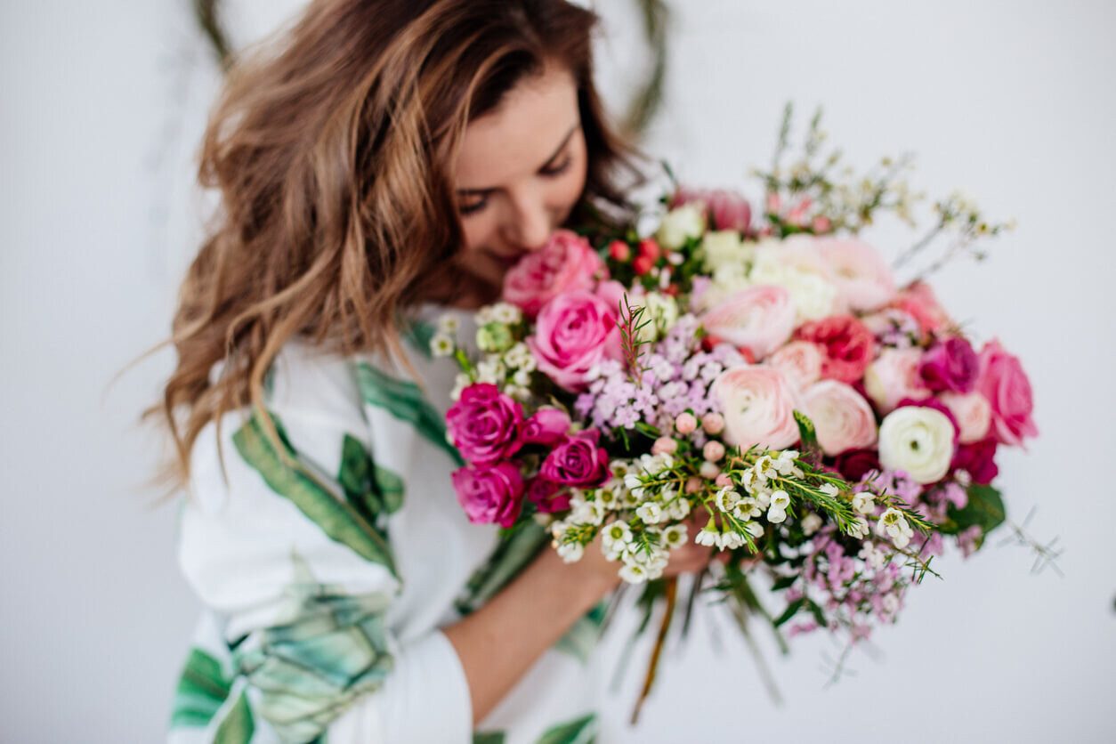 Woman smelling beautiful bouquet of wedding flowers