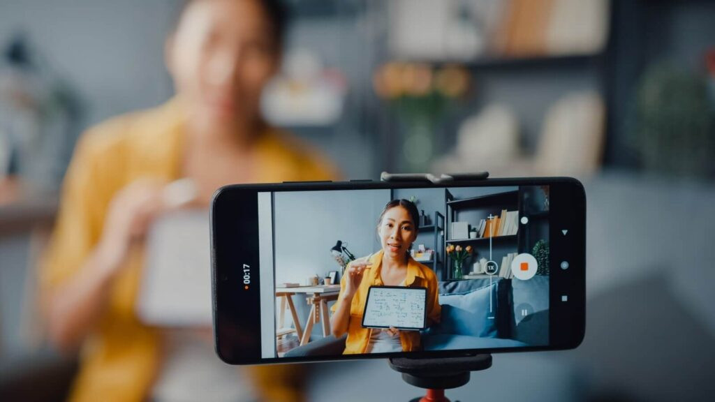 Woman recording instructional video for online class with her phone.
