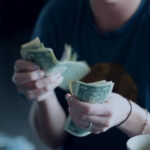 Woman holding dollar bills in her hands.
