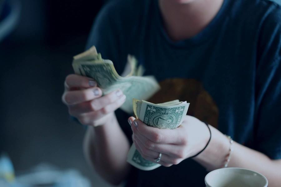 Woman holding dollar bills in her hands.