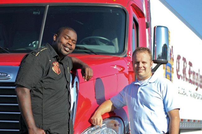 Two men standing in front of a semi-truck