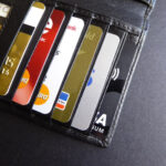 A close-up photo of payment cards inside a wallet placed on a black surface