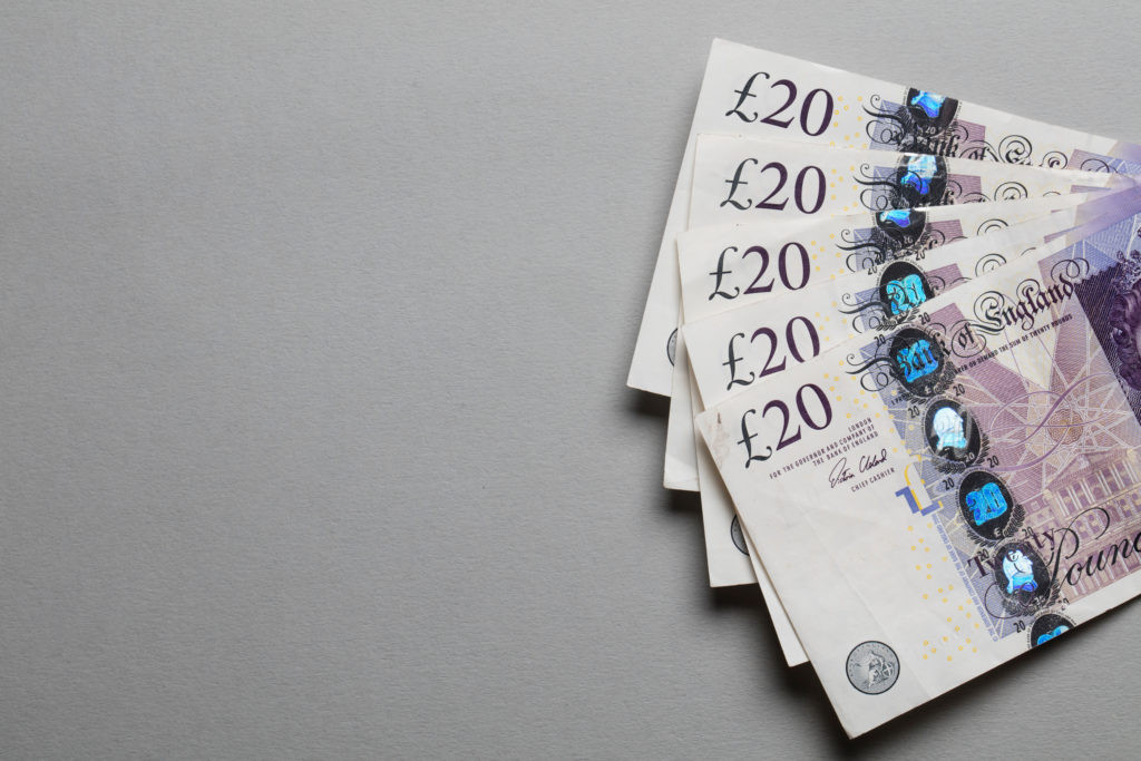 British pound notes featuring historical figures and the monarch