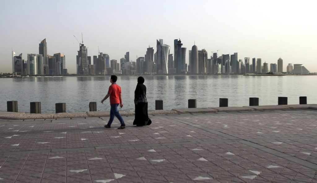 Couple walks by the sea in Doha, Qatar