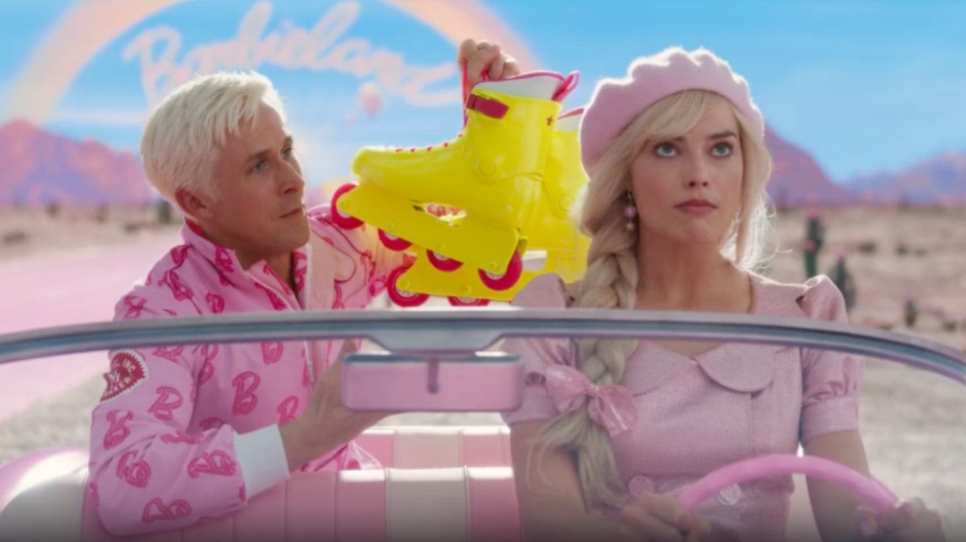 Margot Robbie as Barbie, smiling and holding a microphone, on a pink stage with a background of cheering people