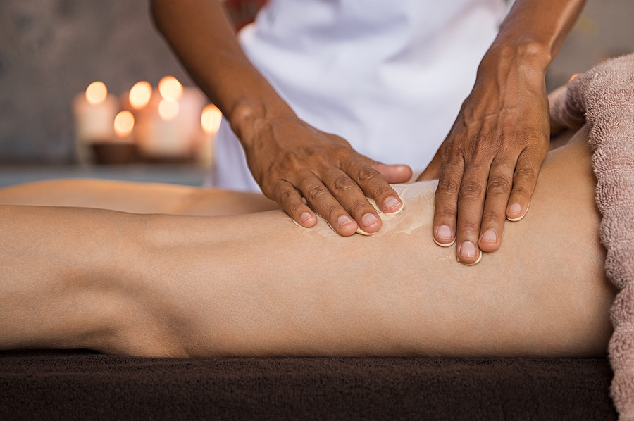 Hands of beauty therapist doing massage to woman in spa