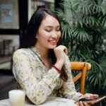 Woman smiling while using Bumble on her smartphone