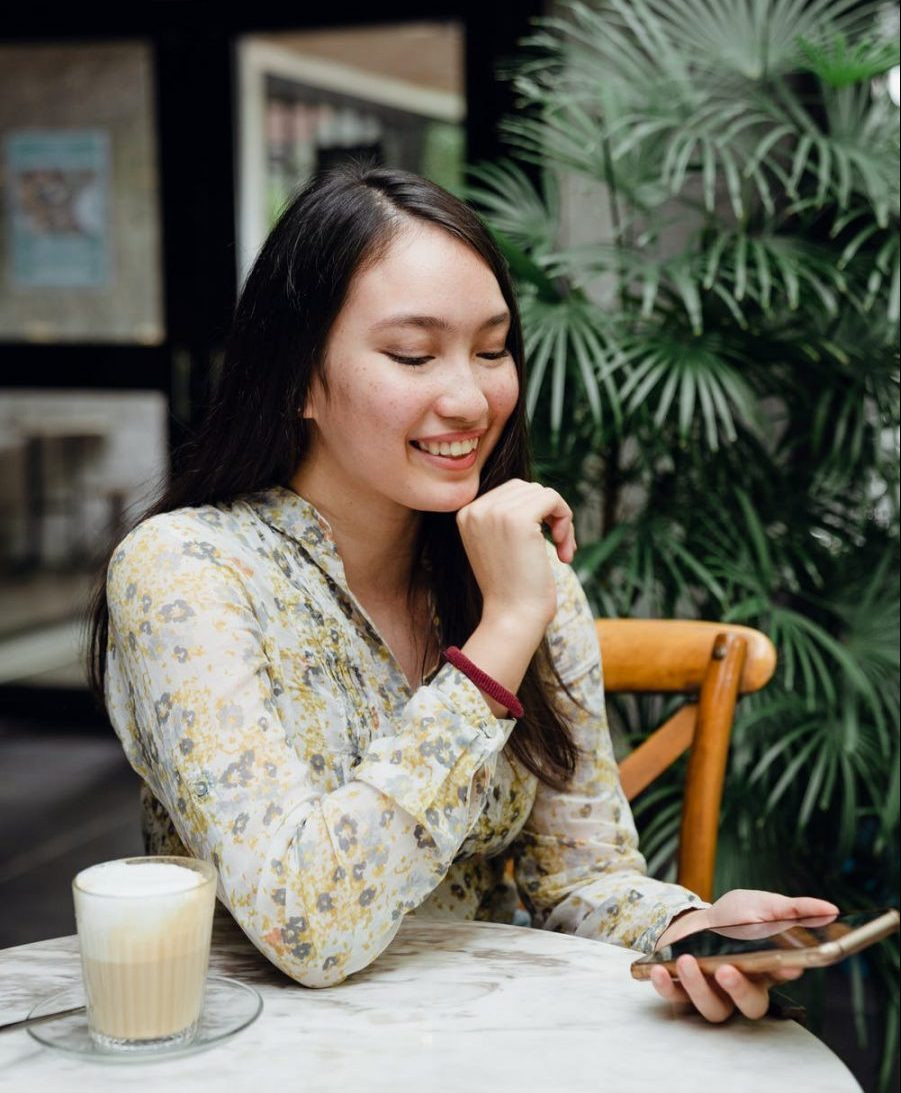 Woman smiling while using Bumble on her smartphone