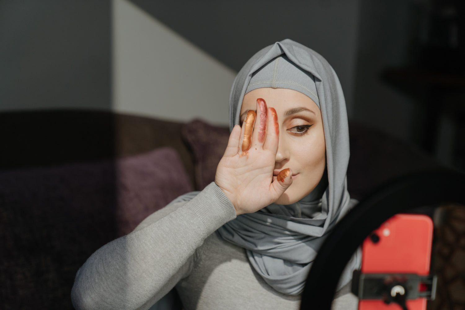 A woman shoots a makeup demo using a mobile phone