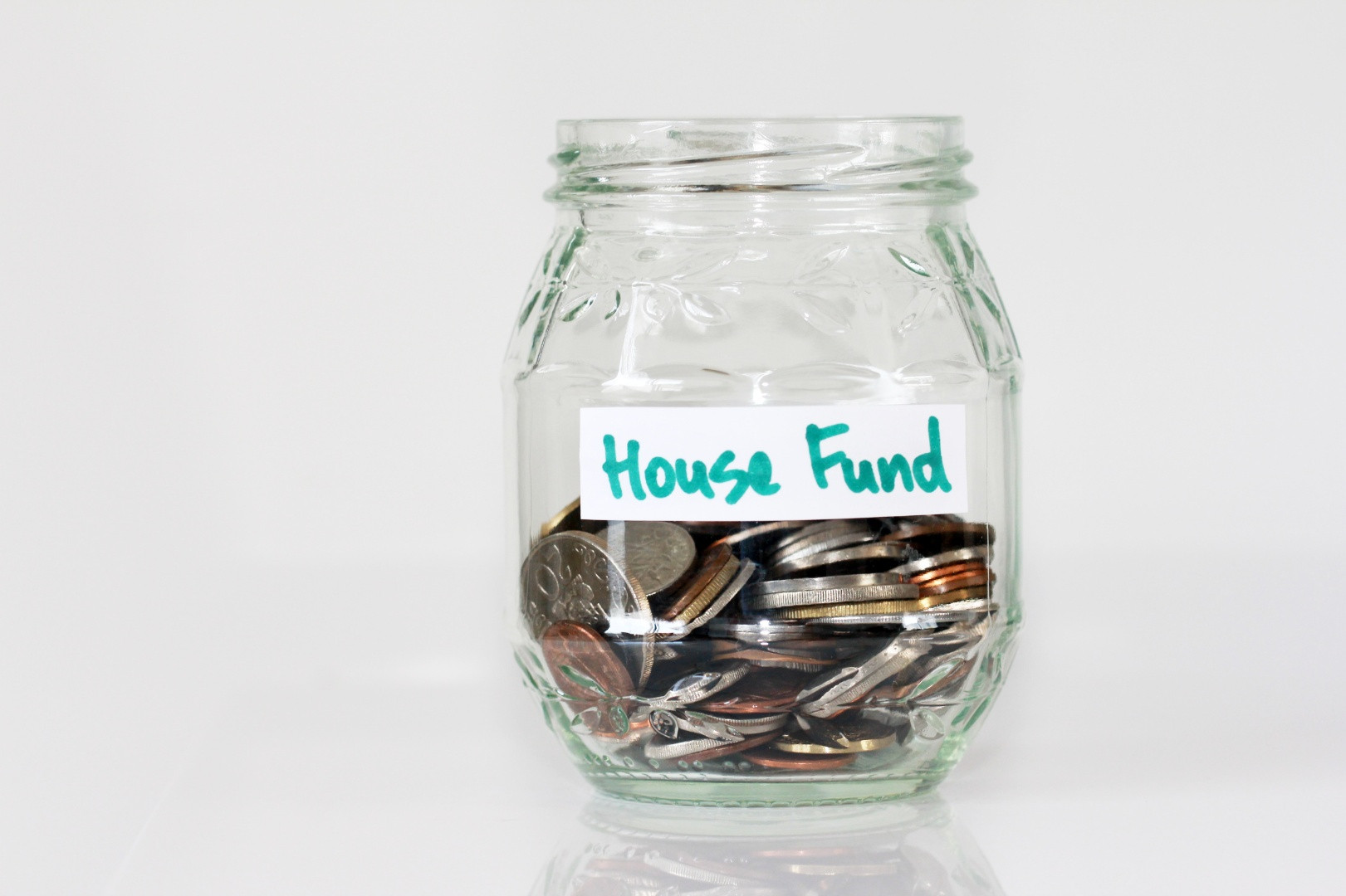Glass jar half-filled with coins and labeled