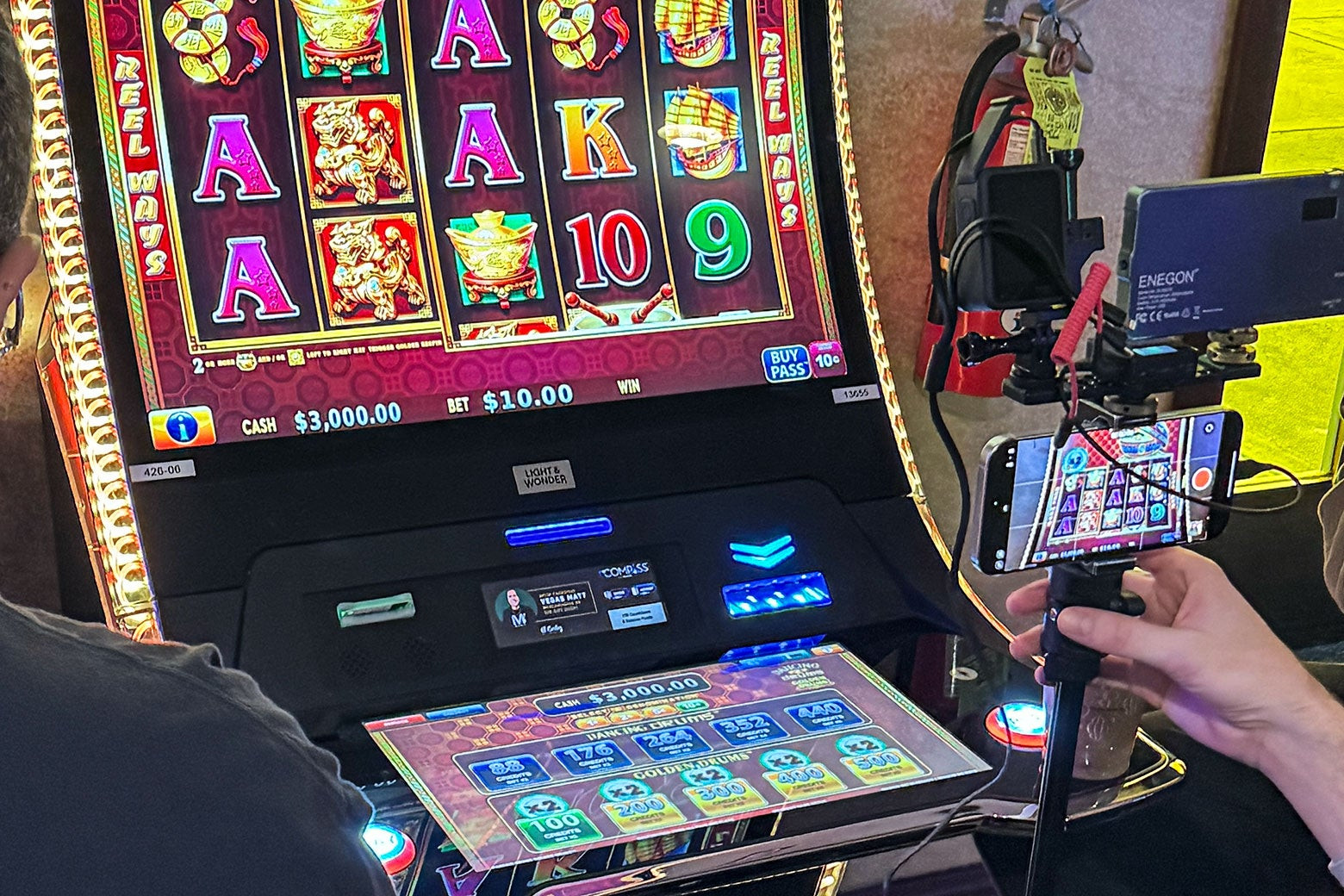 A cellphone mounted on a tripod captures a slot machine inside a Vegas casino.