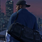 Grand Theft Auto 5 Franklin wearing a cap backwards and holding a duffel bag. Skyscrapers are lit up in the background