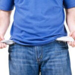 Person looking at empty pockets representing financial difficulties