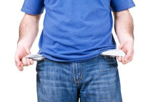 Person looking at empty pockets representing financial difficulties