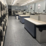 Interior of a modern laundromat with rows of washing machines and dryers.