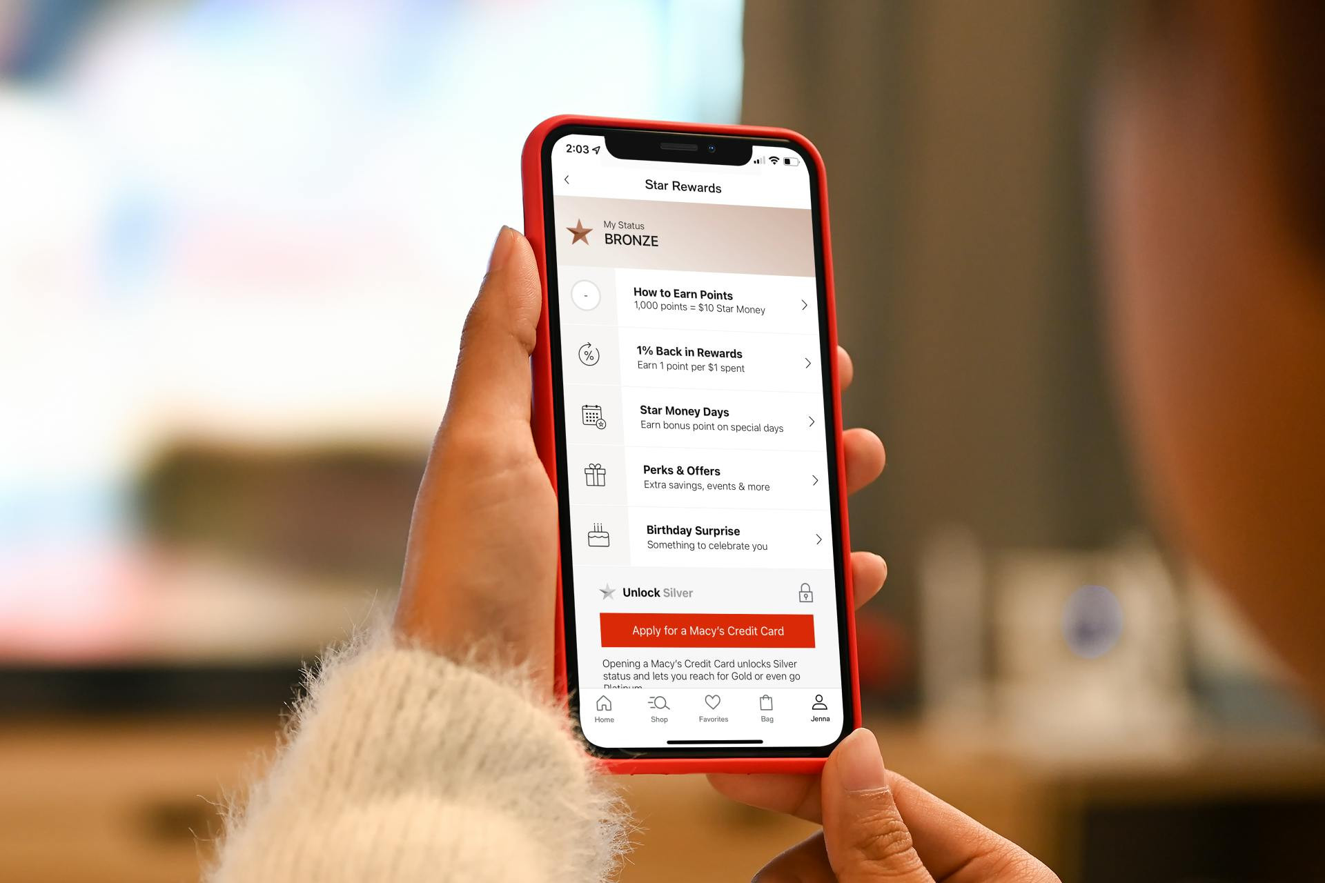Woman looking at Macy's Star Rewards Tracking App on her phone