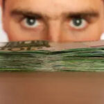 Man staring over a pile of money