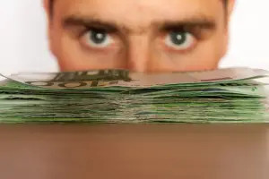 Man staring over a pile of money