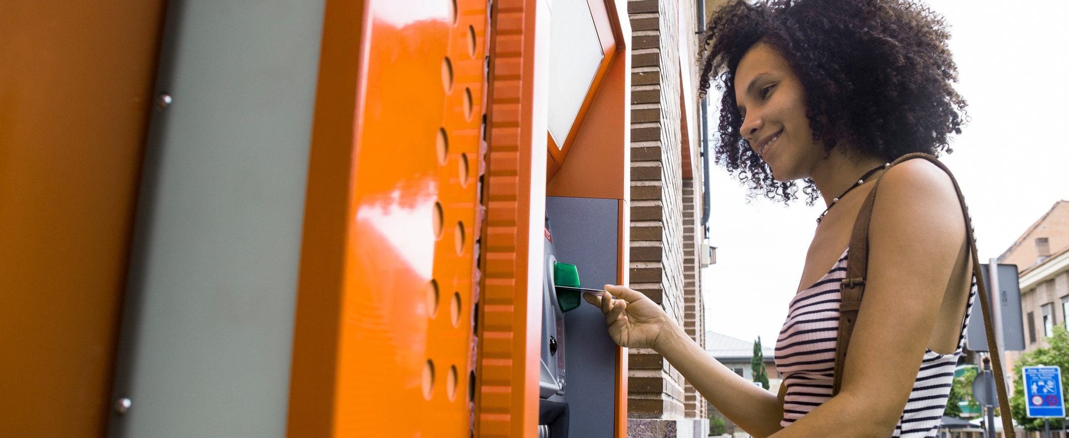 A woman using an ATM to withdraw money, highlighting the convenience of accessing funds.