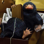 Niffler on a pile of money in Hogwarts Legacy, symbolizing wealth accumulation