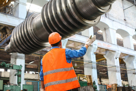 Welding engineer examining blueprints in a high-tech engineering environment