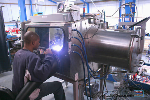 Aerospace welder working on aircraft components in a manufacturing facility