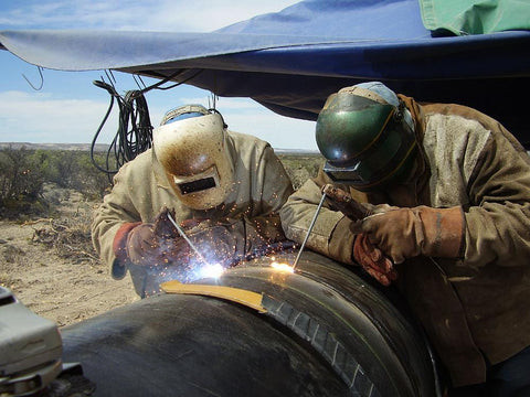 Welders Welding a Pipeline