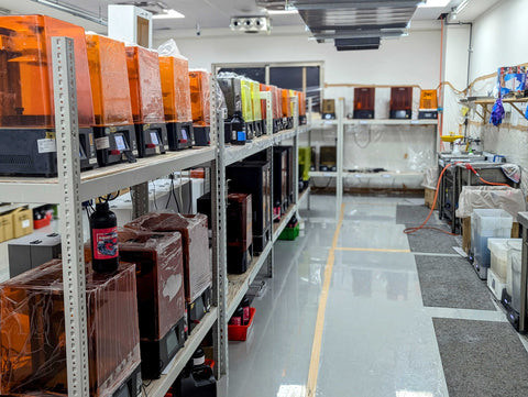 A picture of a line of 3D printers in a 3D print farm.