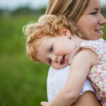 A woman holds a young child