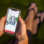 Woman holds a cell phone that is displaying the Poshmark app