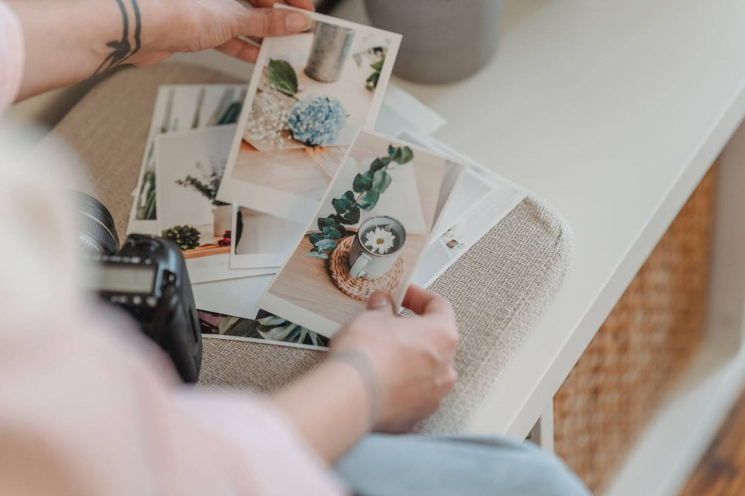 Person sorting printed photographs, symbolizing print on demand