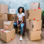 Woman amidst shipping boxes, illustrating dropshipping
